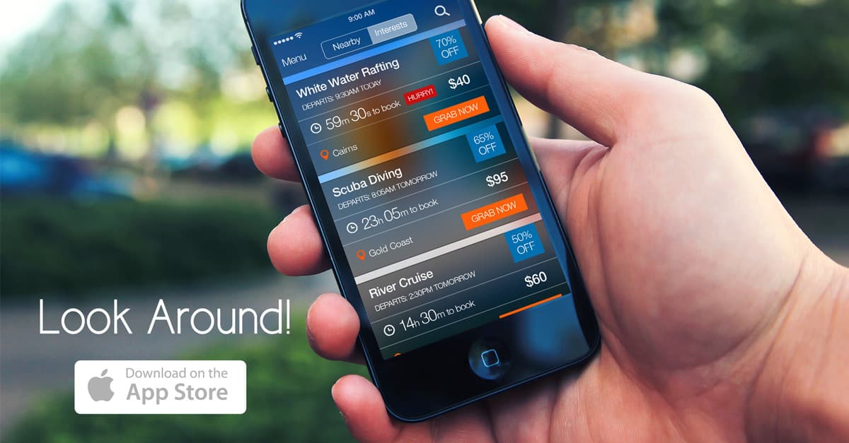 Hand holding an iPhone showing goStandby last-minute deals: white water rafting 70% off, scuba diving and a river cruise