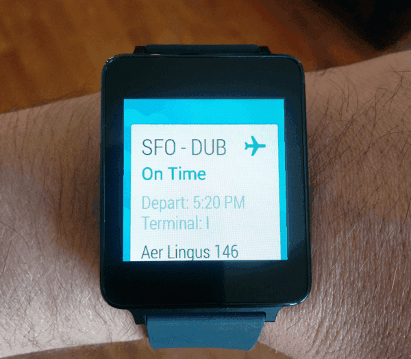 Android smartwatch on a wrist showing an Aer Lingus flight card: SFO to DUB, on time, departing 5:20 PM from Terminal 1